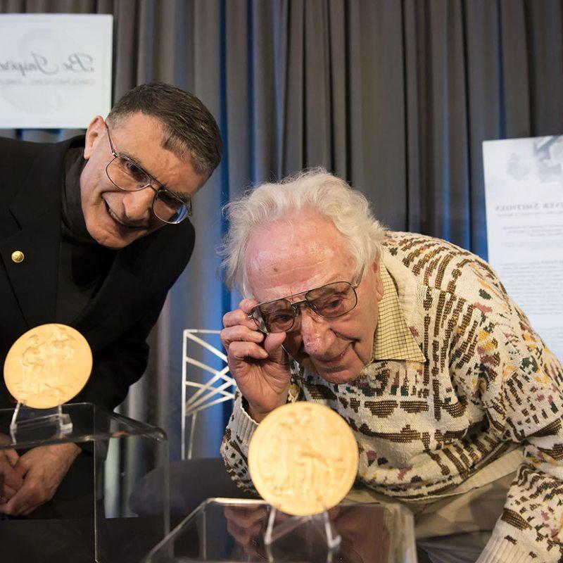 Oliver Smithes and 阿齐兹Sancar look at their Nobel Prize Medals.