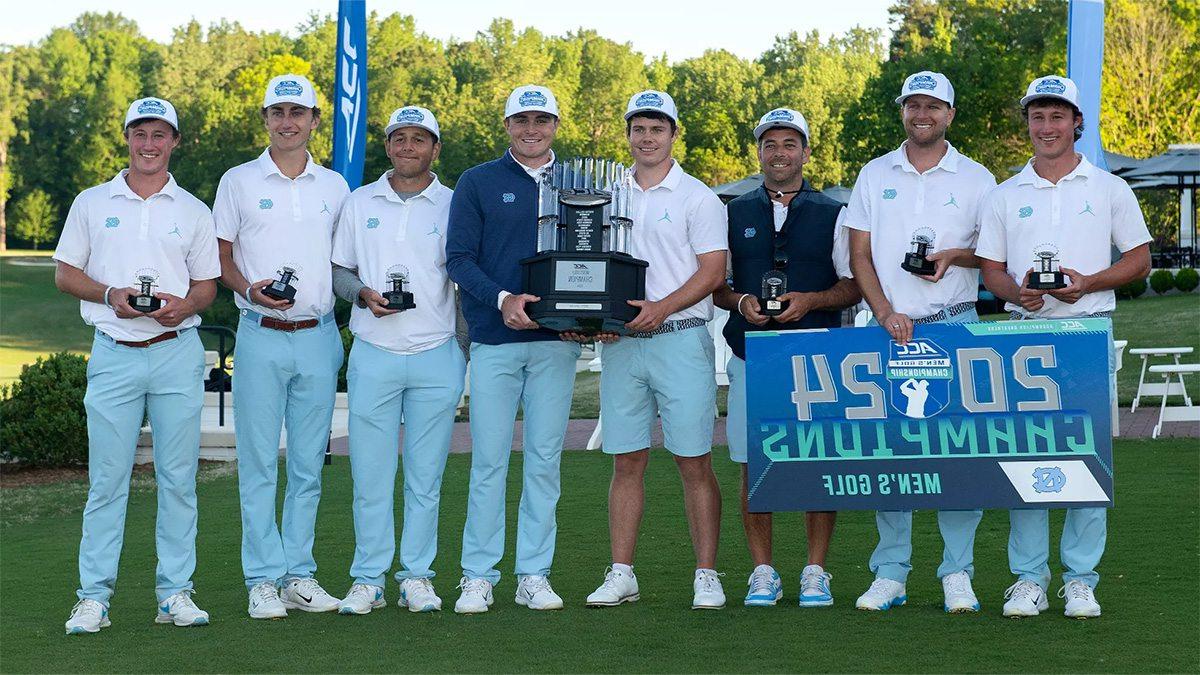 Members of the Carolina men's golf team posing for a group photo after winning the ACC championship while holding a trophy and a banner that reads 